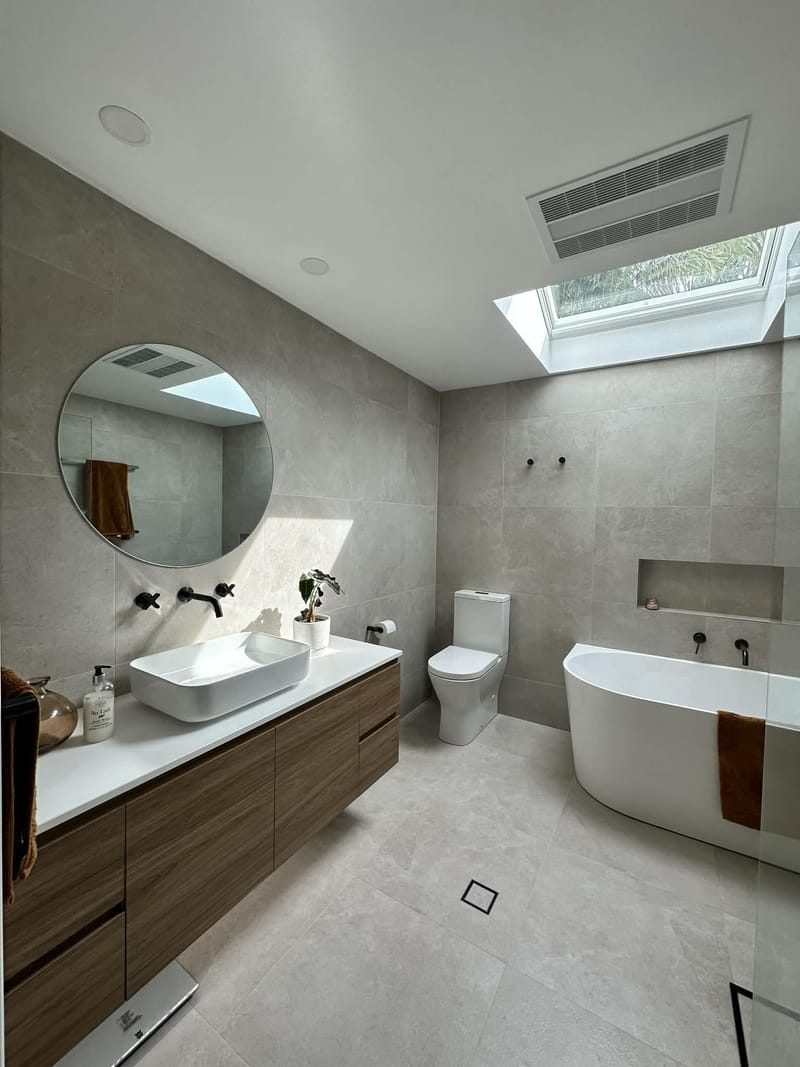 Bathroom renovation in large-format stone-look tiles with skylight — ASP Build & Co