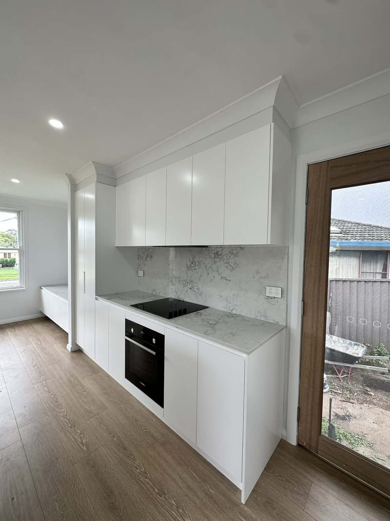 White kitchen and timber-look floor in a home renovation by ASP Build & Co