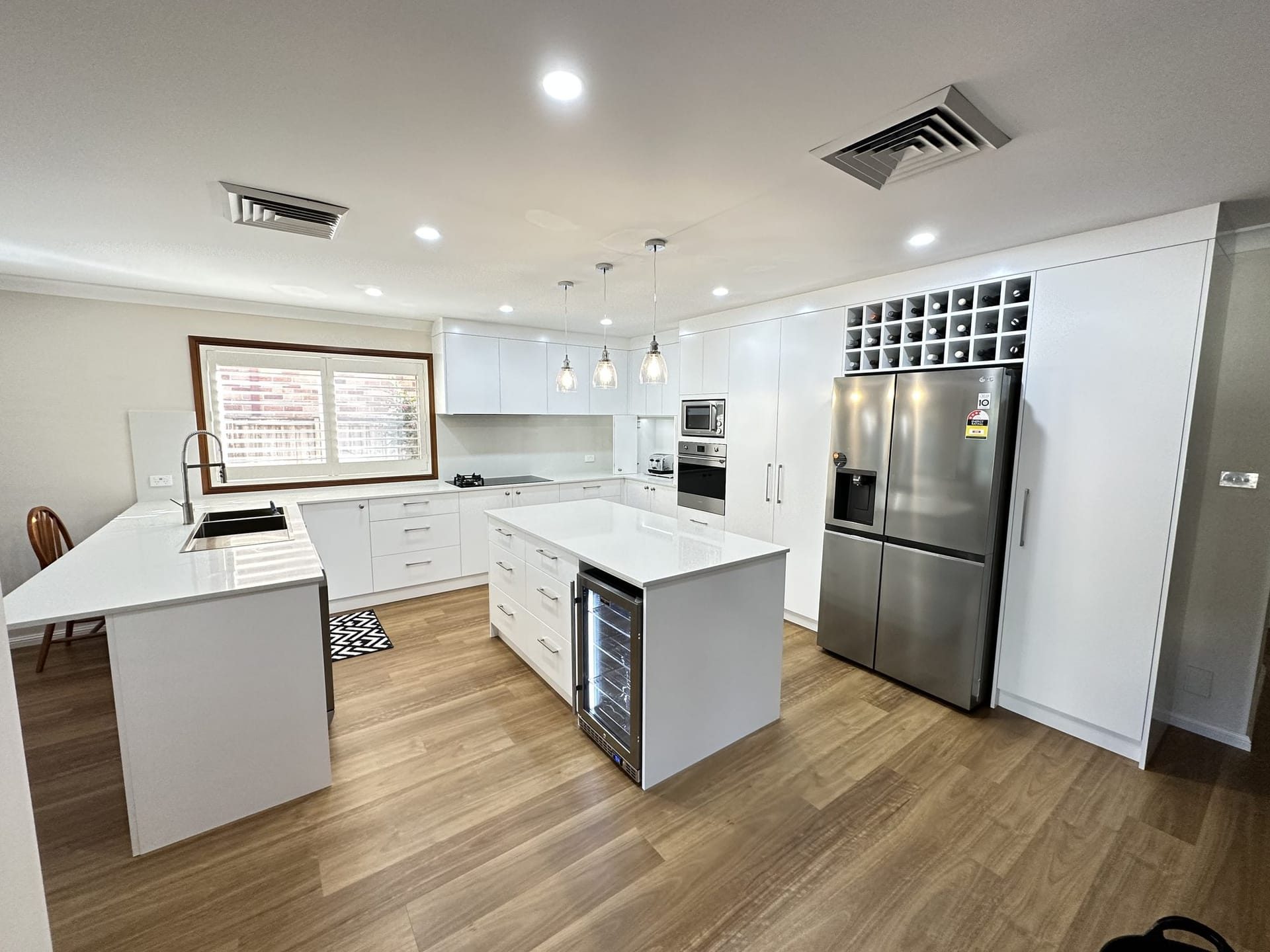 White kitchen renovation with island, wine rack and quality appliances by ASP Build & Co, Adelaide