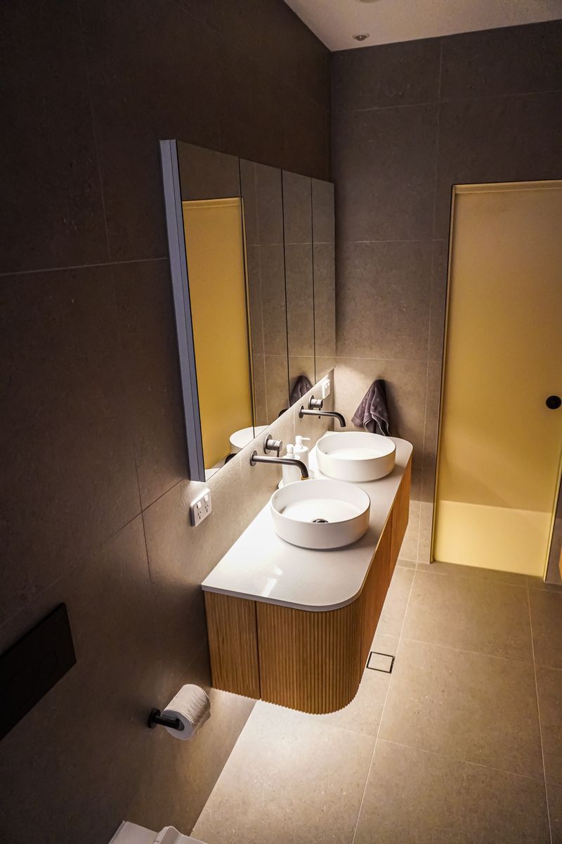 Curved timber vanity with double vessel basins in a Kingswood bathroom renovation
