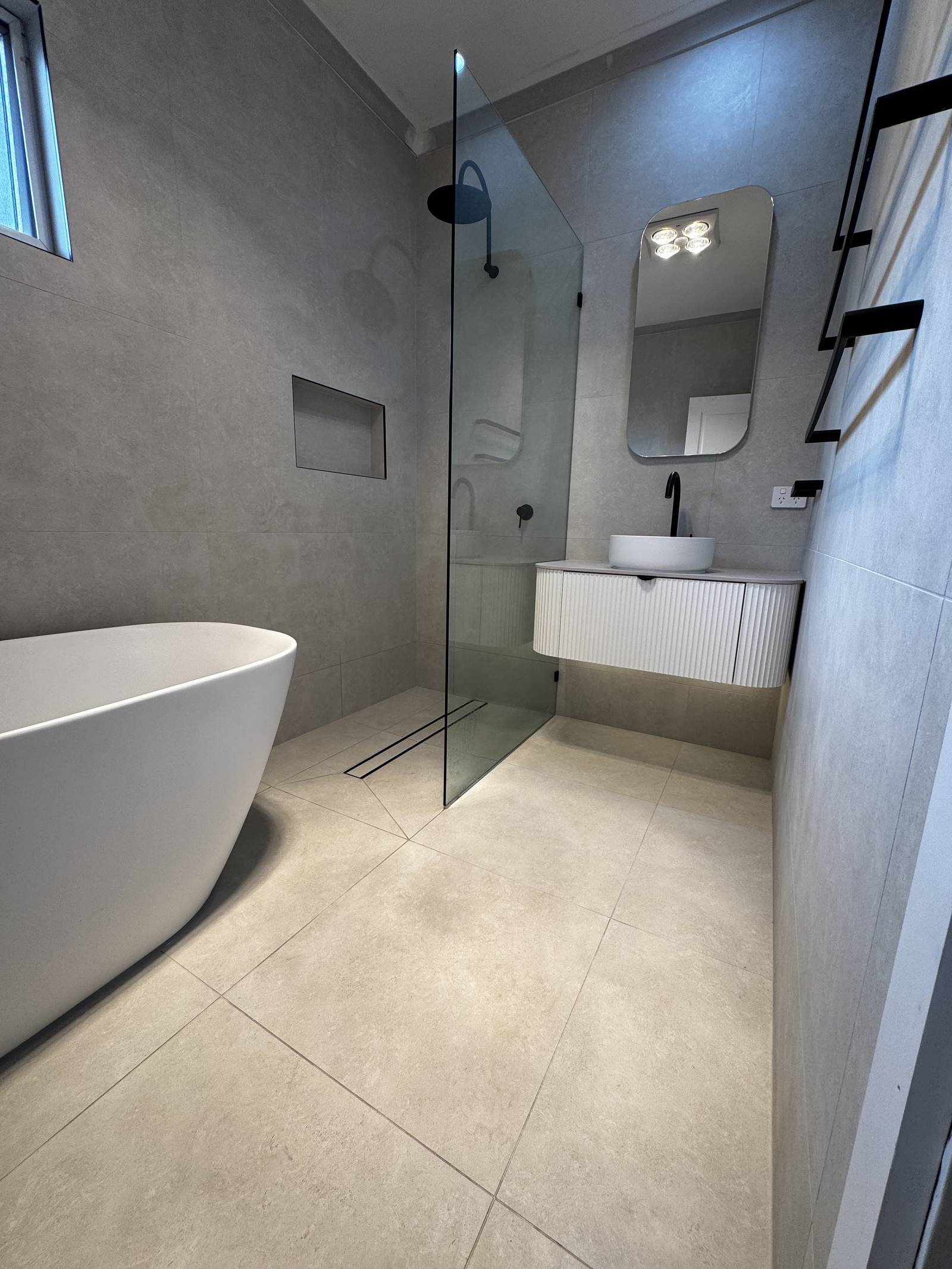 Freestanding bath, frameless shower panel and floating vanity in a renovated Magill bathroom