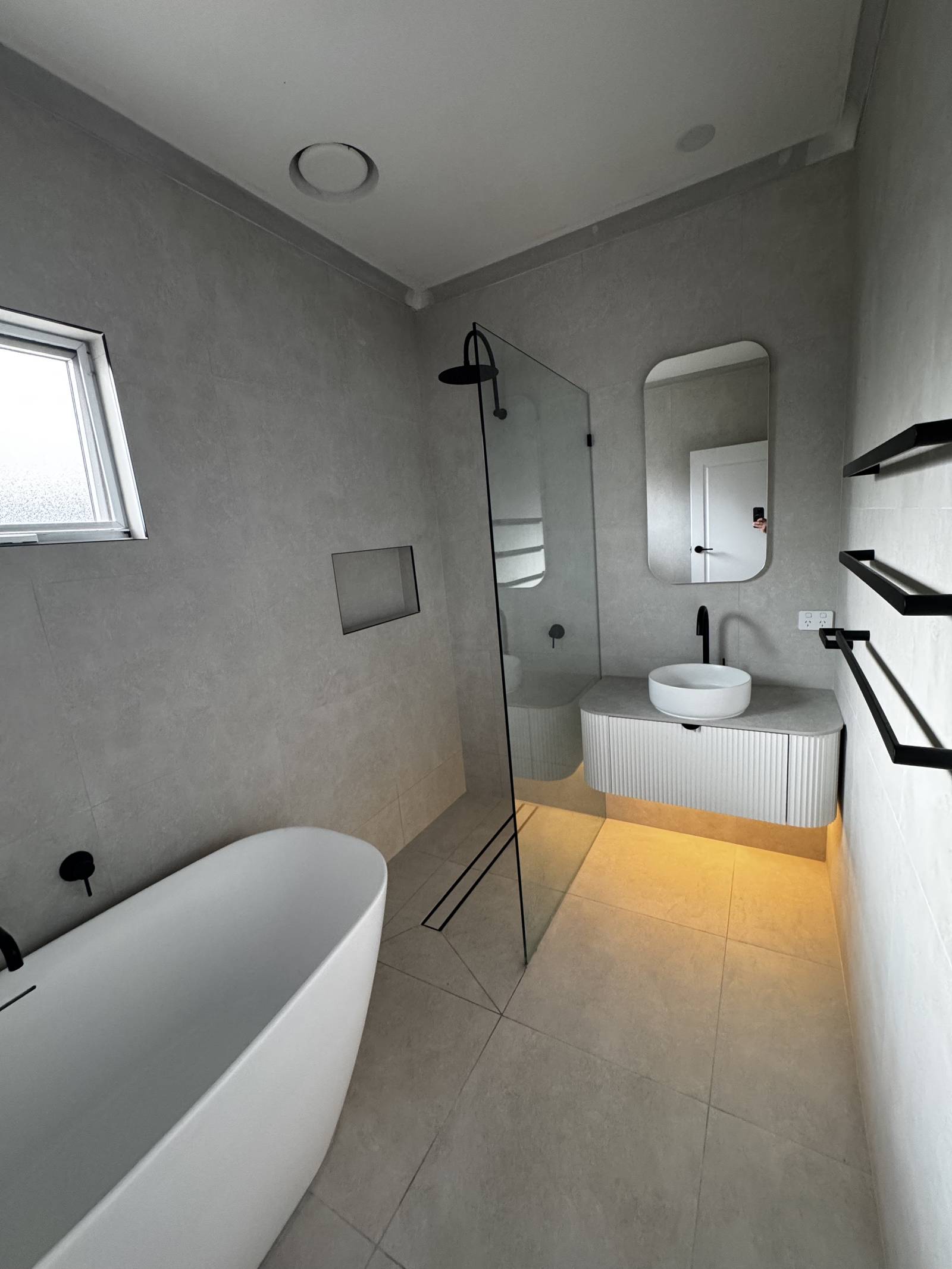 Renovated Magill bathroom with a freestanding bath, walk-in shower, tiled niche and rounded mirror