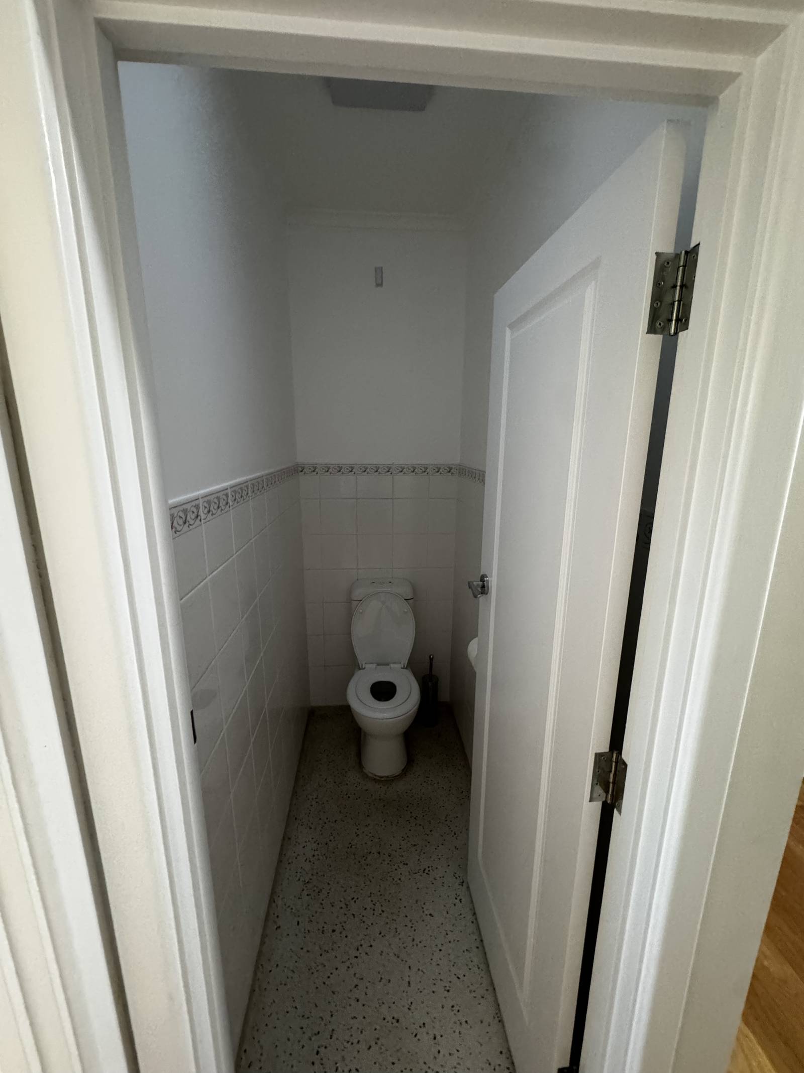 Magill separate toilet before the renovation, with half-height white wall tiles