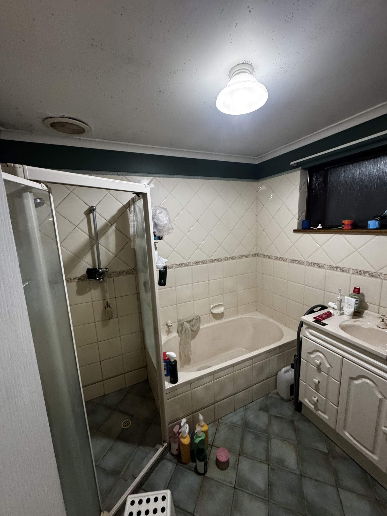 Modbury bathroom before renovation, with a corner shower, bath and diamond-pattern tiles