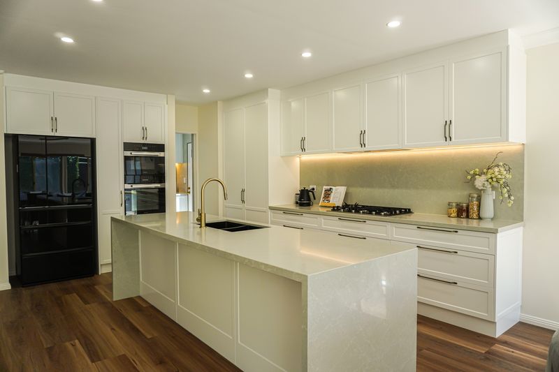 Renovated Torrens Park kitchen with long stone island, waterfall ends and white shaker cabinetry