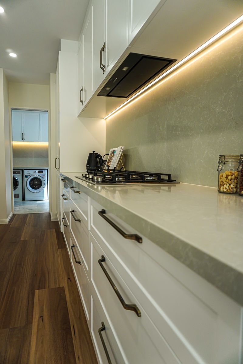 Gas cooktop with concealed rangehood and LED-lit stone splashback in a Torrens Park kitchen