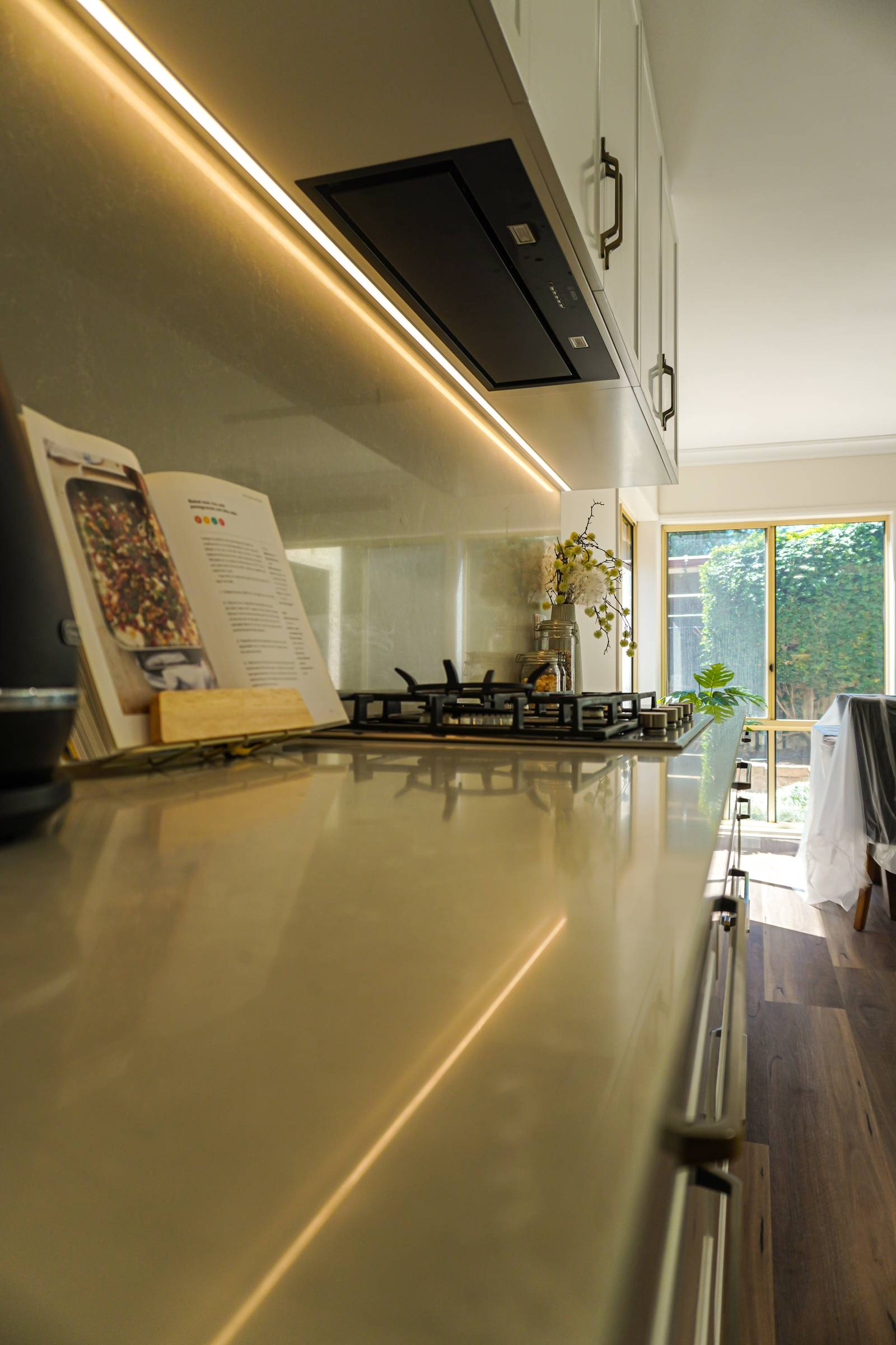 Stone benchtop under LED strip lighting with garden doors beyond, Torrens Park kitchen
