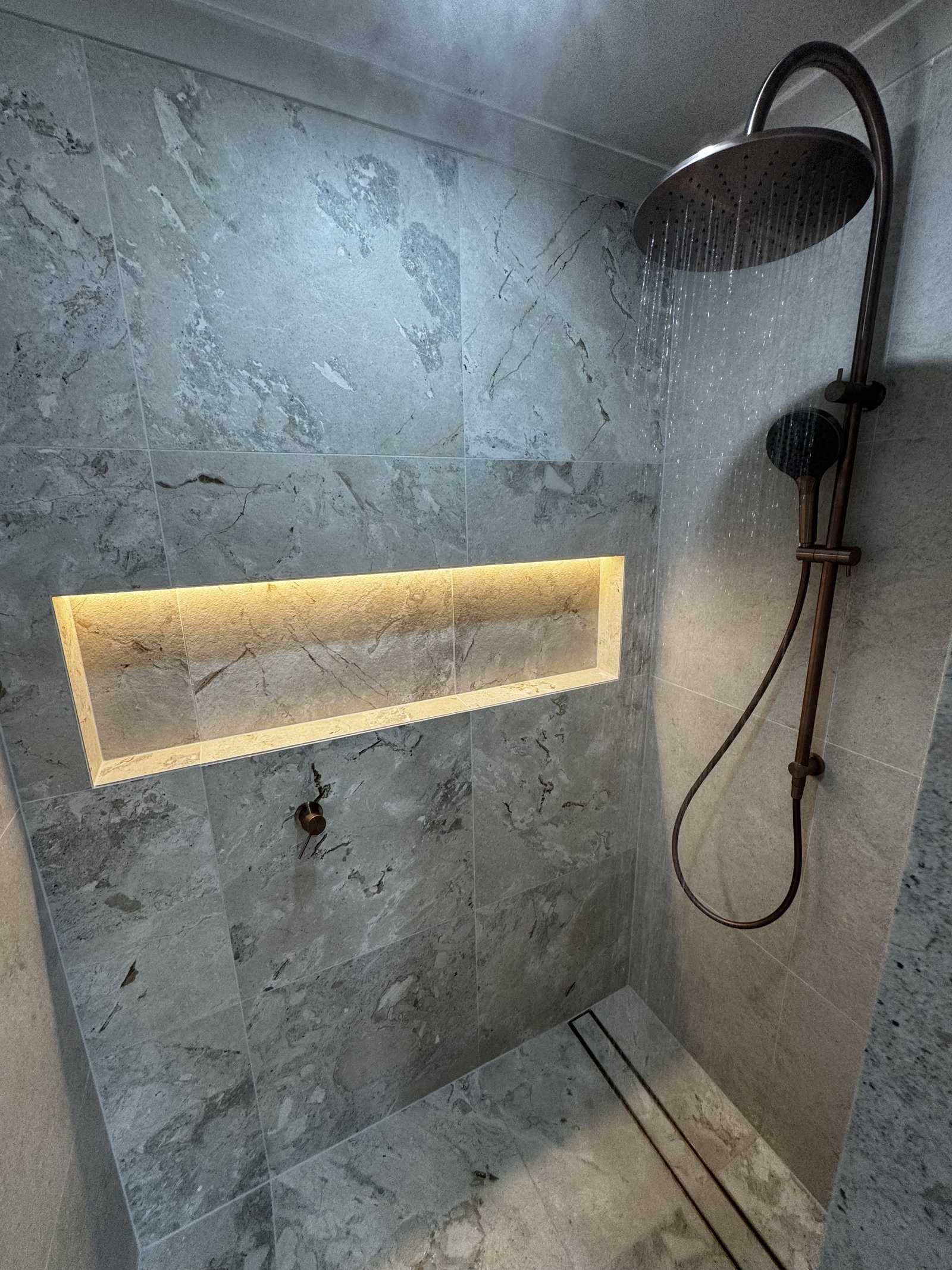 Walk-in shower with LED-lit niche, rail shower and linear drain in a Torrens Park master ensuite