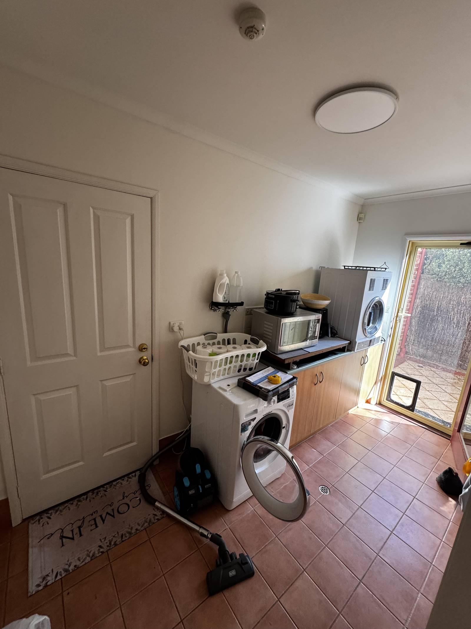 Torrens Park laundry before renovation, with terracotta floor tiles and freestanding machines
